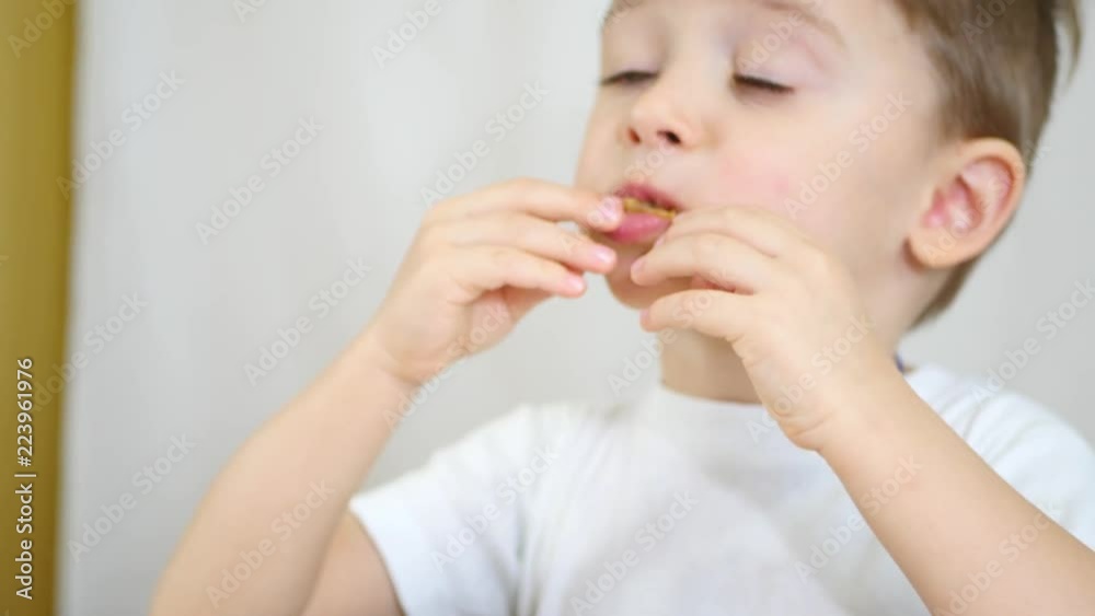 A child is eating potato chips from a white plate, close-up. Movement of the camera. A child is eating potato chips from a white plate, close-up. Movement of the camera.