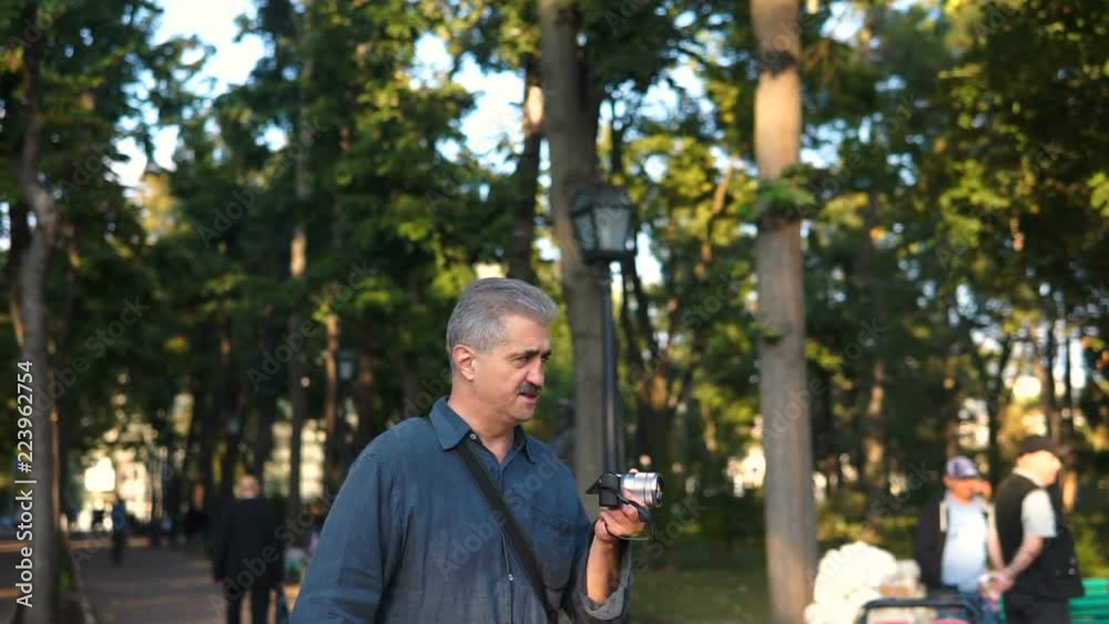 Photographer man taking photo on mirrorless camera Photographer man taking photo on mirrorless camera