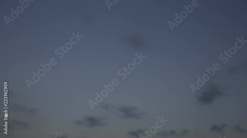timelapse of clouds crossing the amazing sky at sunset. The clouds cross slowly from right to left and appear to be orange blue and purple. the clouds are grey, purple, yellow and red