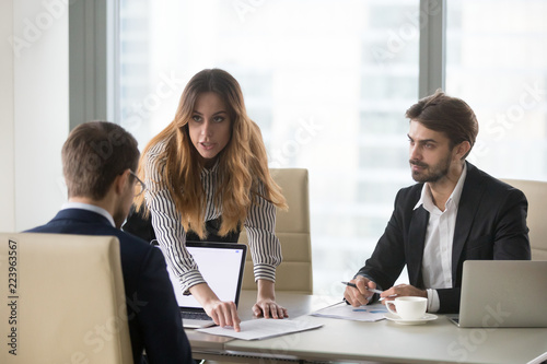 Mad female worker talking to company CEO proving point of view, showing mistake in agreement or contract, business partners disagree with male colleague on deal terms. Failed partnership concept