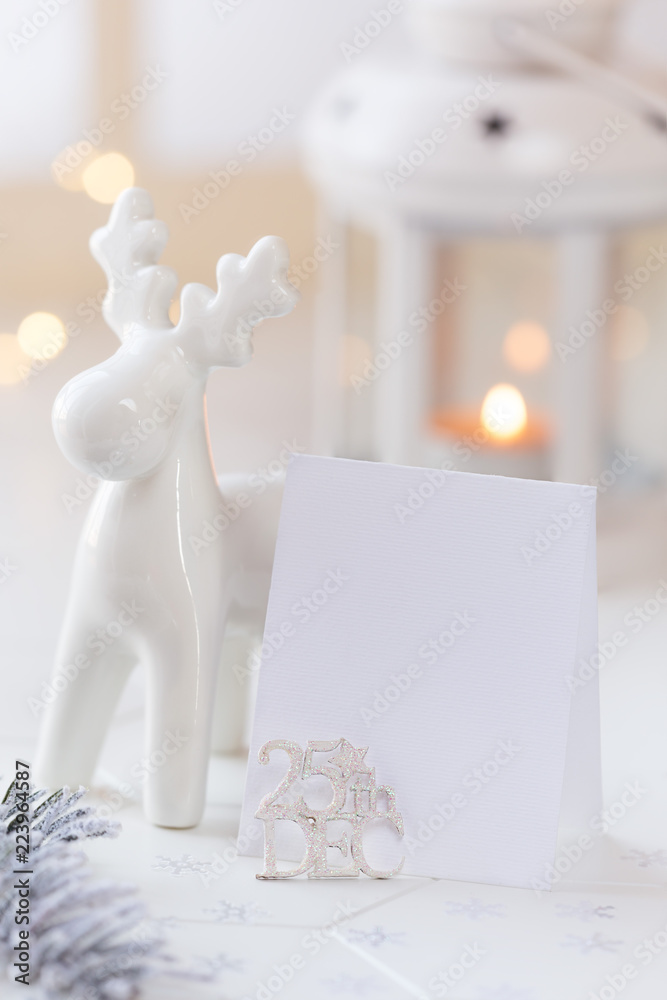 Christmas greeting card and giftswith golden ribbon and festive decorations - whiet reindeer, baubles and fir branches - at the background Christmas greeting card and giftswith golden ribbon and festive decorations - whiet reindeer, baubles and fir branches - at the background