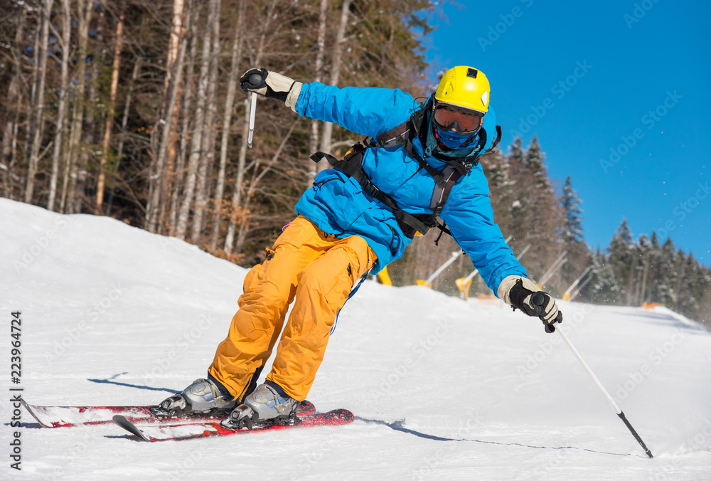 Low angle shot of a professional skier skiing on the slope recreation active sport seasonal resort sportspeople adrenaline extreme concept