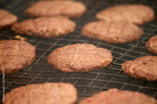 BEEF BURGERS COOKING ON A BARBECUE