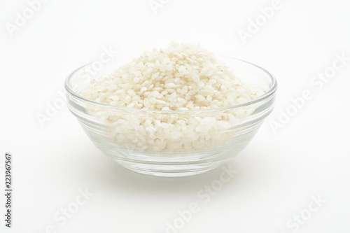 Slika na platnu Arroz redondo crudo en un bol de cristal sobre fondo blanco