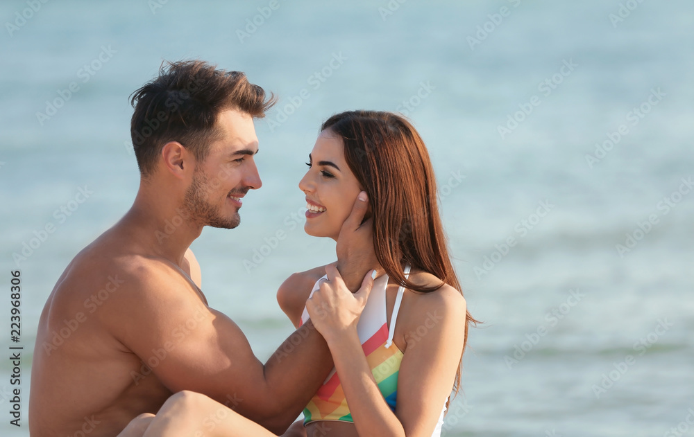 Happy young couple at beach on sunny day Happy young couple at beach on sunny day