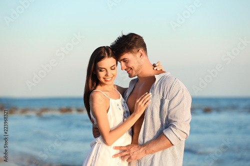Happy young couple posing near sea on beach © New Africa
