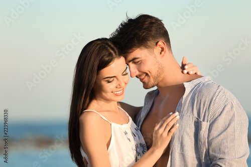 Happy young couple posing near sea on beach