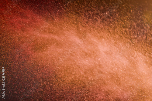 ABSTRACT IMAGE OF RED AND ORANGE PARTICLES SWIRLING IN TURBULENT AIR