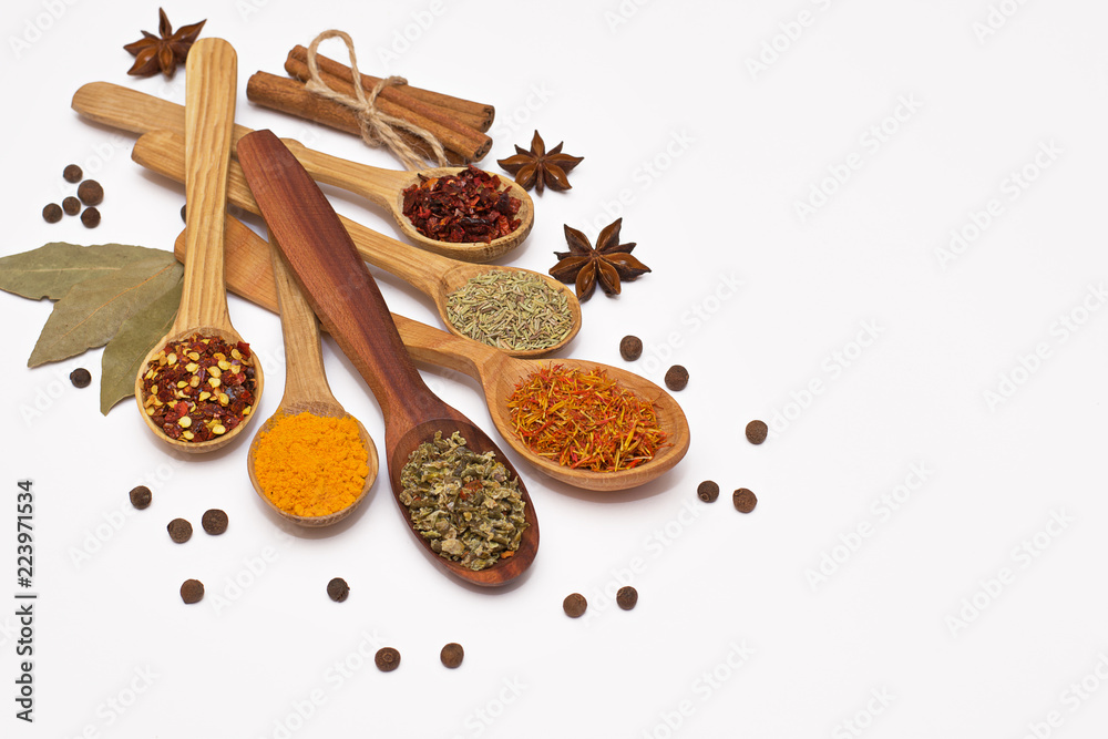 Fototapeta premium Spice. Spice in a wooden spoon. Herbs. Curry, saffron, turmeric, pepper and other isolated on white background.