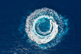 Ein Motorboot formt einen Kreis aus Luftblasen auf dem blauen Meer
