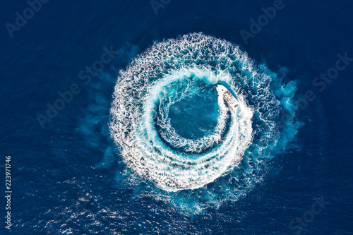 Fototapeta Ein Motorboot formt einen Kreis aus Luftblasen auf dem blauen Meer