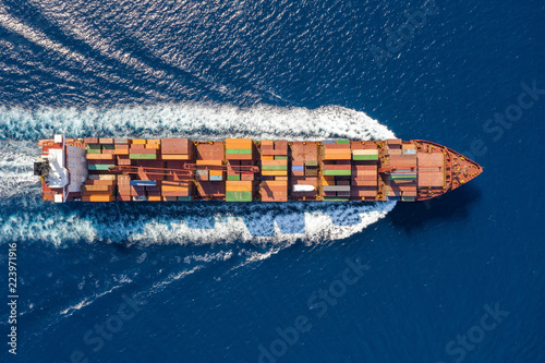Top down Ansicht auf ein beladenes Containerschiff in voller Fahrt über blauem Meer