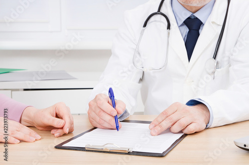 Doctor and patient are discussing something, just hands at the table, medical insurance.