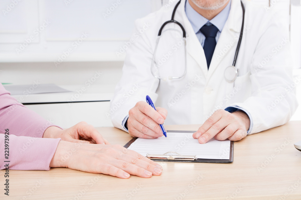 Doctor and patient are discussing something, just hands at the table Doctor and patient are discussing something, just hands at the table