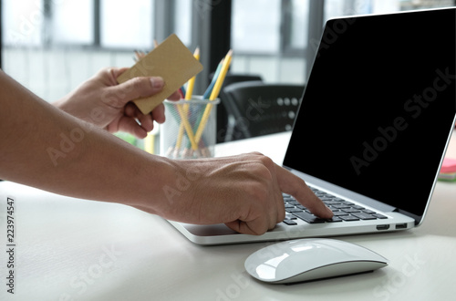 Person holding the credit card in hand and using laptop.