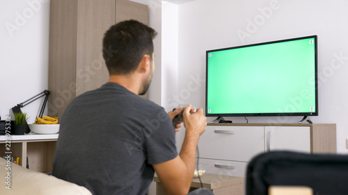 Man playing with joystick while sitting in his couch. Relaxing time