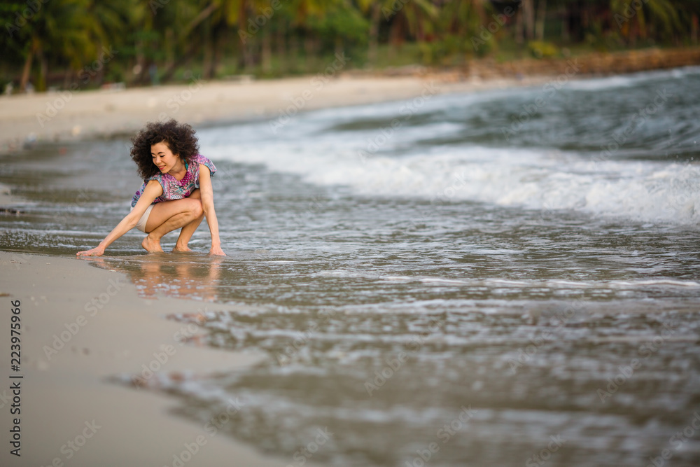 Obraz premium Mixed race woman on a tropical beach.