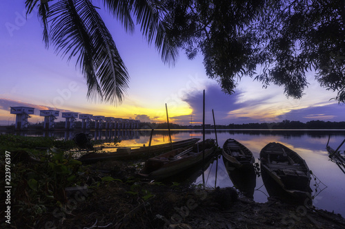 A small wooden fishing boat parked in front of the floodgate at Pakphanang district, Nakhon Si Thammarat province, Thailand.