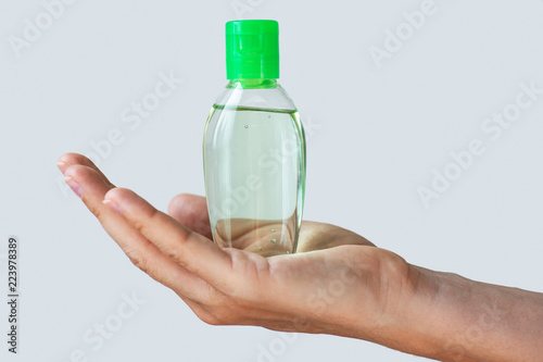 Fototapeta Naklejka Na Ścianę i Meble -  Hand with a small bottle of hand sanitizer