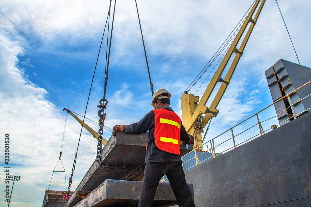 stevedore labor working on plate of steel slab  lifting by the ship crane, loading discharging operation for transfer the cargo shipment in export and import, works by stevedore labor on port terminal