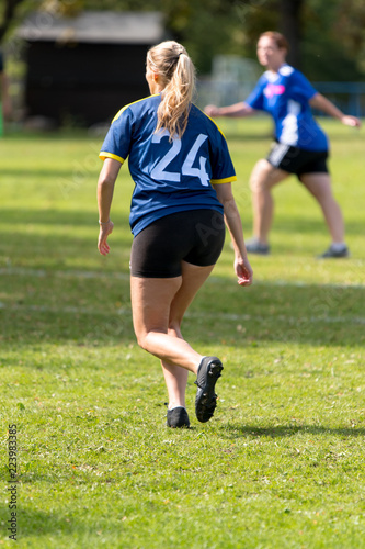 young woman running on soccer field