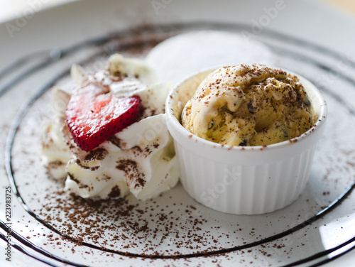 Wallpaper Mural Yellow icecream with white cream and strawberry in white plate closeup. Torontodigital.ca