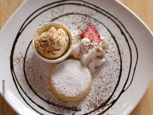 Wallpaper Mural Yellow icecream with white cream and strawberry in white plate closeup top view. Torontodigital.ca