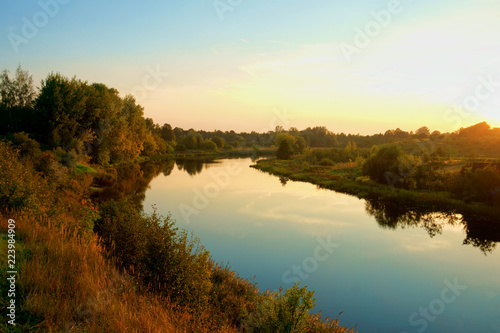 Fototapeta Naklejka Na Ścianę i Meble -  Sunrise reflected in calm river water surface