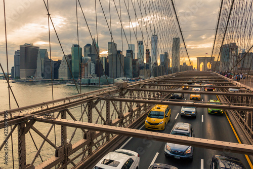 Traffic on Brooklyn Bridge at sunset with Manhattan skyline in the background (New York, USA)