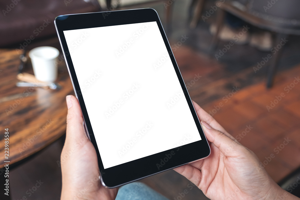 Mockup image of hands holding black tablet pc with blank white desktop screen Mockup image of hands holding black tablet pc with blank white desktop screen