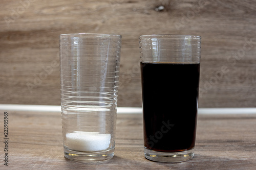 Bild von einem 200ml Glas Cola und einem 2.Glas indem sich die Menge Zucker befindet ,21 Gramm,die in dem Getränk dieser Größe enthalten ist. photo