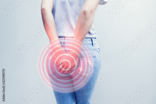 Woman hand holding her bottom because having Abdominal pain and Hemorrhoids, Health care concept. photo