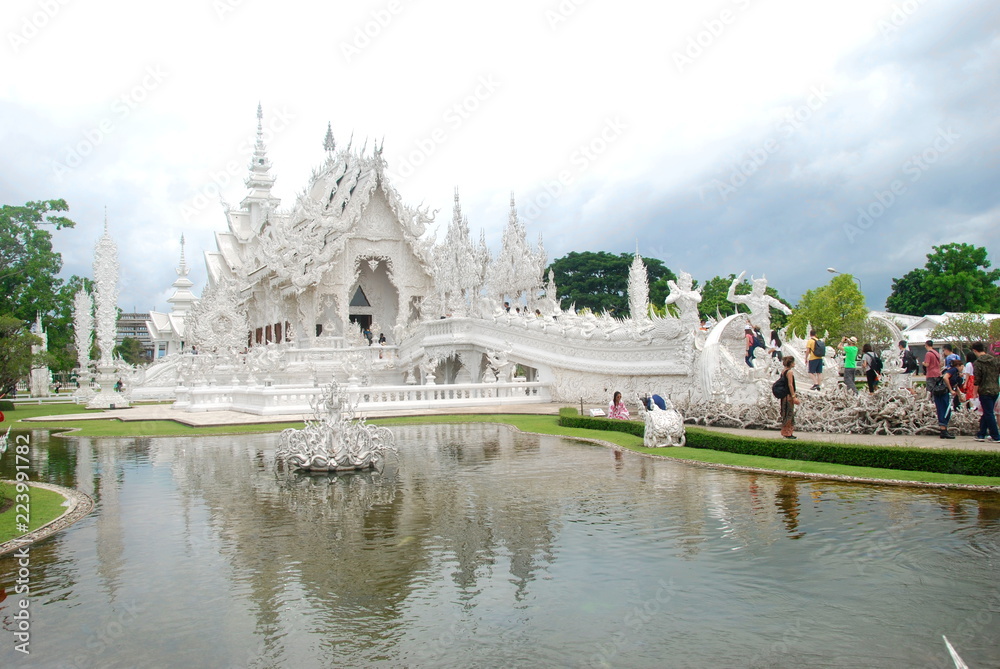 Entrance into Wat Rong Khun alias the White Temple of Chiang Rai in Thailand with long queue of tourists