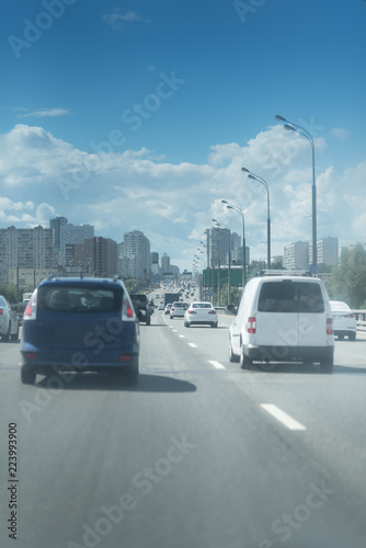 cars in motion on asphalt road and blue sky with clouds