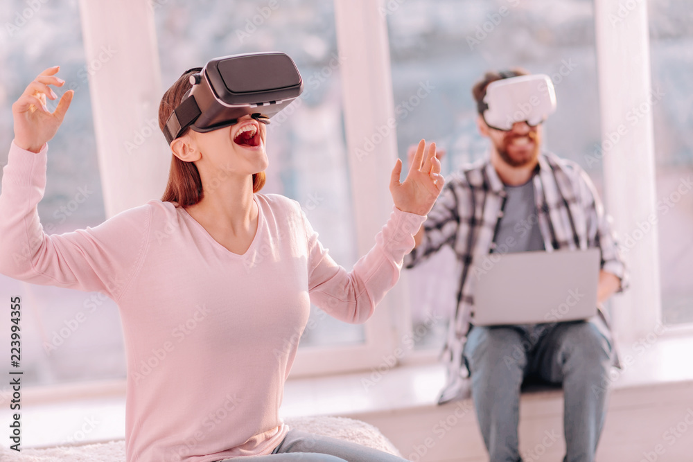 Feeling scared. Young woman in VR glasses shouting something having virtual adventures Feeling scared. Young woman in VR glasses shouting something having virtual adventures