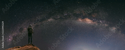 Night sky full of star and milky way, with traveller with backpack enjoying beautiful sky at night