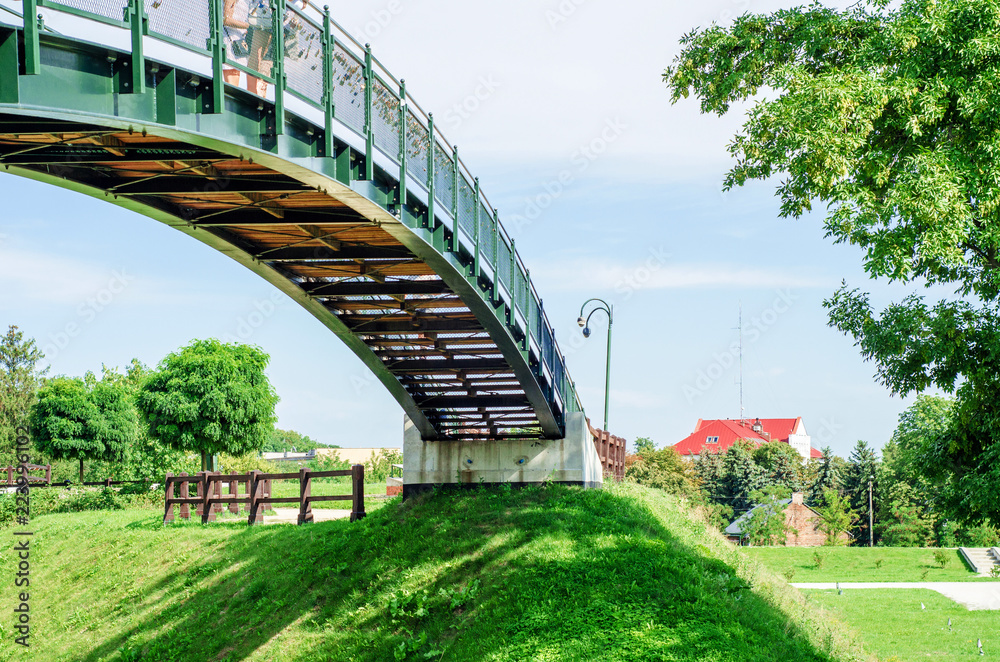 Arched bridge between two green hills