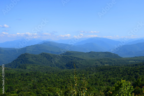 Green mountains and blue sky. Beautiful summer landscape with multilayered hills  fog and forest. Main Caucasian ridge  Adygea.