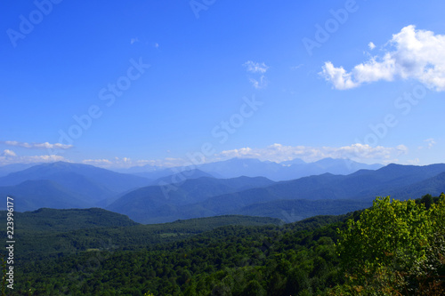 Green mountains and blue sky. Beautiful summer landscape with multilayered hills  fog and forest. Main Caucasian ridge  Adygea.
