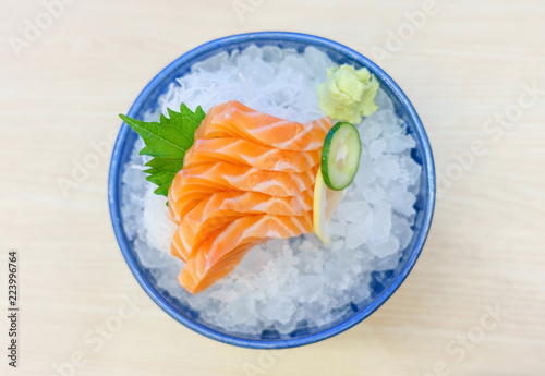 Salmon sashimi on ice serve with fresh wasabi and carrot slide, Japanese food style. Top view with copy space and text