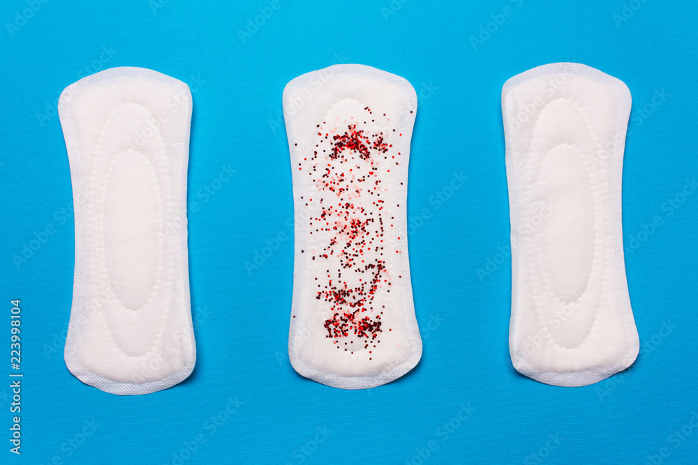 three menstrual pads on a blue background. Concept menstruation three menstrual pads on a blue background. Concept menstruation