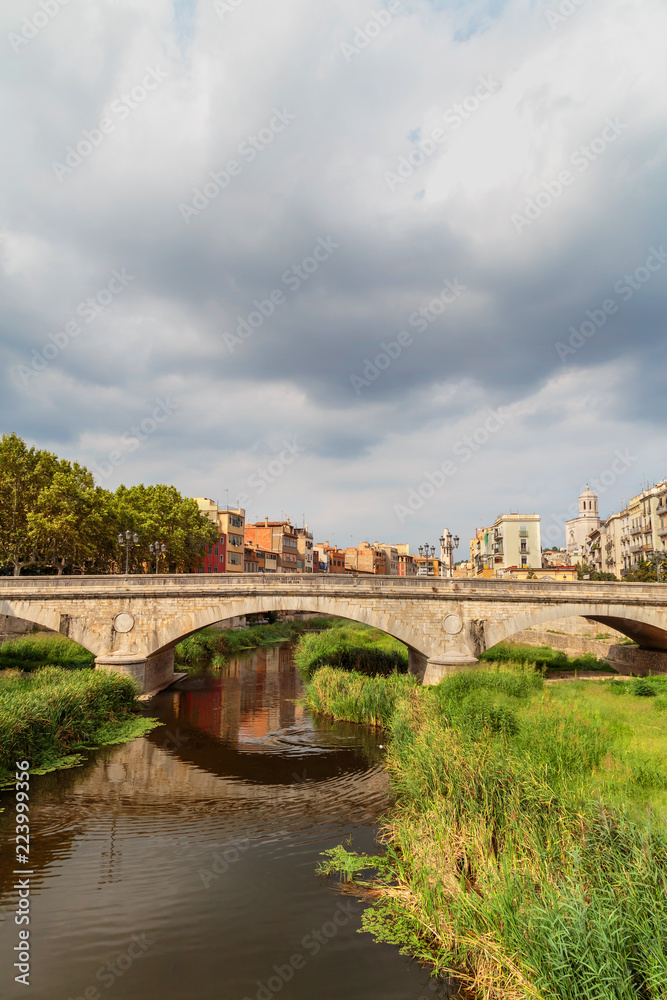 old bridge in Girona on the background of a stormy sky
