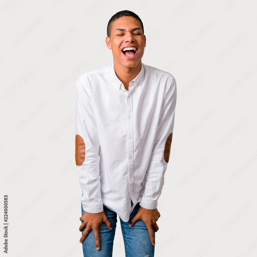 Fototapeta premium Young african american man shouting to the front with mouth wide open on grey background