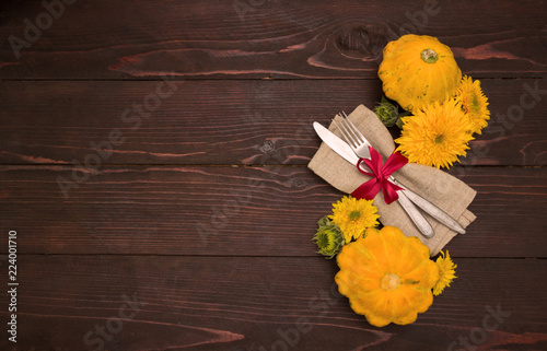 Autumn table setting.Fork and knife ,napkin, pumpkin and sunflowes on wooden table.Halloween or Thanksgiving day  background photo