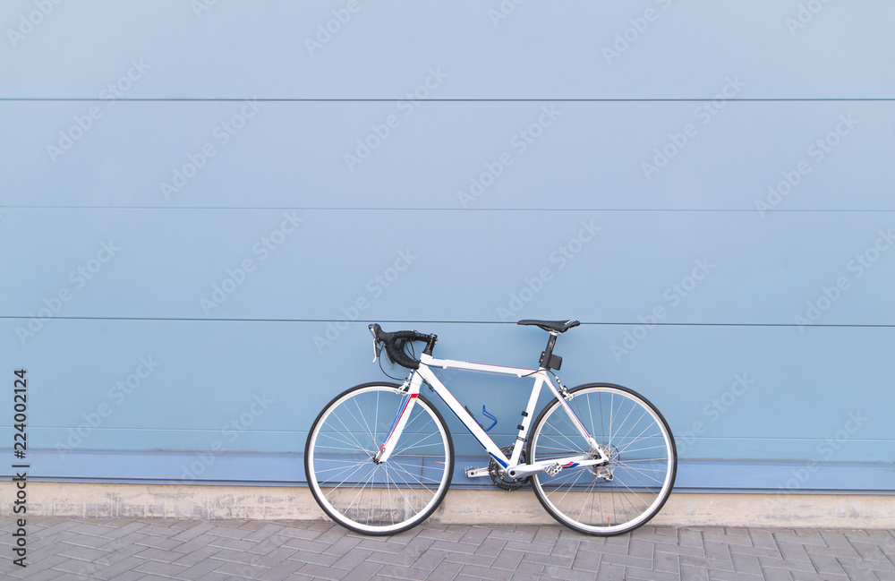 Fototapeta premium White highway bike on a pastel blue background. Sports concept. Copyspace