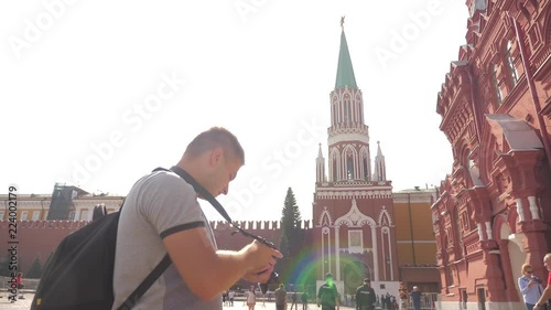 Travel and technology. Happy tourist man looks the navigator smartphone State Historical Museum taking selfie with backpack. slow motion video. on Red Square in Moscow, Russia Kremlin. tourist