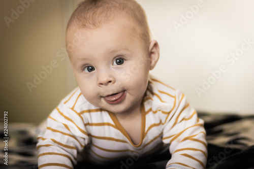 Portrait of a expressive happy baby, holds head up. baby development concept photo, lifestyle