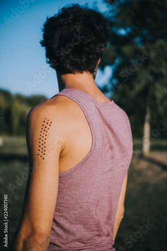 rear view of man with Kambo ceremony burning marks on his arm photo