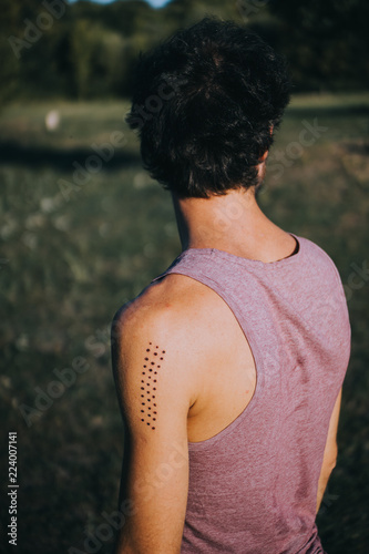 rear view of man with Kambo ceremony burning marks on his arm photo