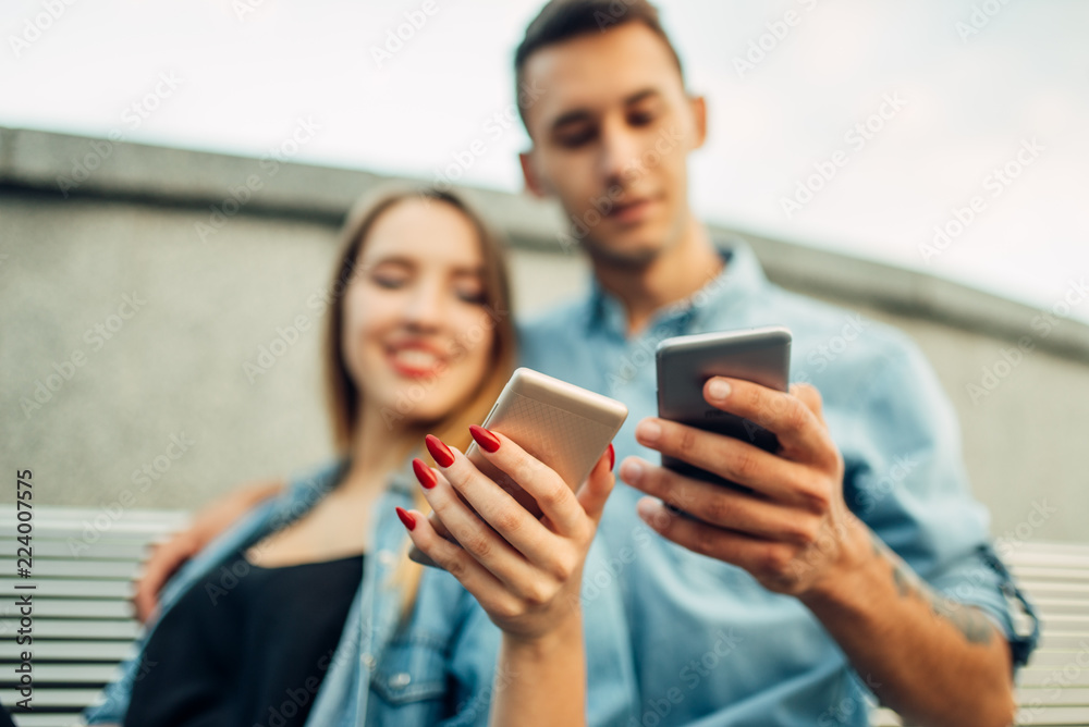 Portrait of addict couple using smartphones